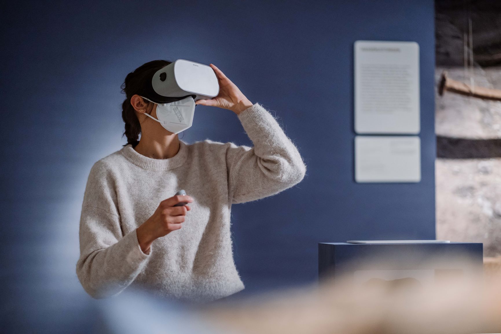 Eine Frau h&auml;lt sich eine Virtual Reality-Brille vor die Augen.