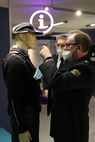 Die Polizeihauptkommissare Wolfgang Schütze (re.) und Lutz Wodarsch (Mitte) geben der uniformierten Puppe noch einen Mundnasenschutz mit. Foto: smac | Jutta Boehme
