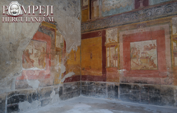 In einer Hausruine in Pompeji sieht man die zu großen Teilen erhaltene Wandmalerei. Einst bedeckte sie die ganz Wand. Die Wände waren zum Teil vollständig mit Wandmalereien bedeckt. Die Motive sind zahlreich: Götter, Menschen, ein Schiff und Säulen sind erkennbar.