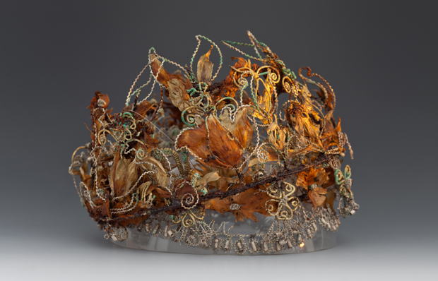 Foto einer sogenannten Totenkrone aus dem 17. Jahrhundert: ein Drahtgeflecht mit Federn sowie getrockneten Kräutern und Blüten.