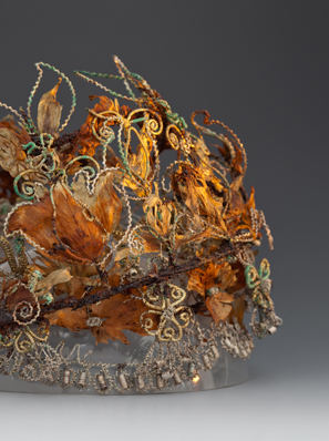 Foto einer sogenannten Totenkrone aus dem 17. Jahrhundert: ein Drahtgeflecht mit Federn sowie getrockneten Kräutern und Blüten.
